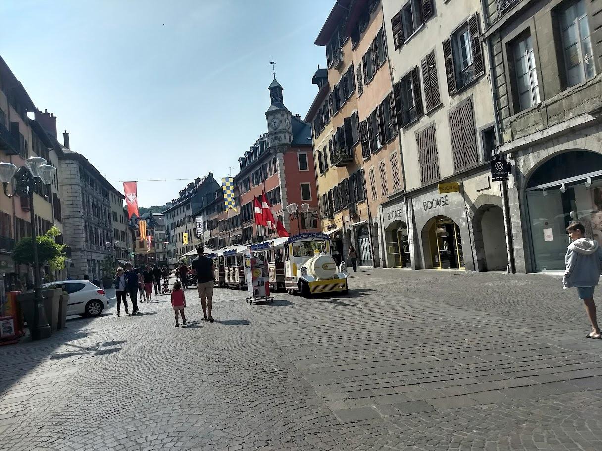 Traveler walking through stone archway in Annecy old town