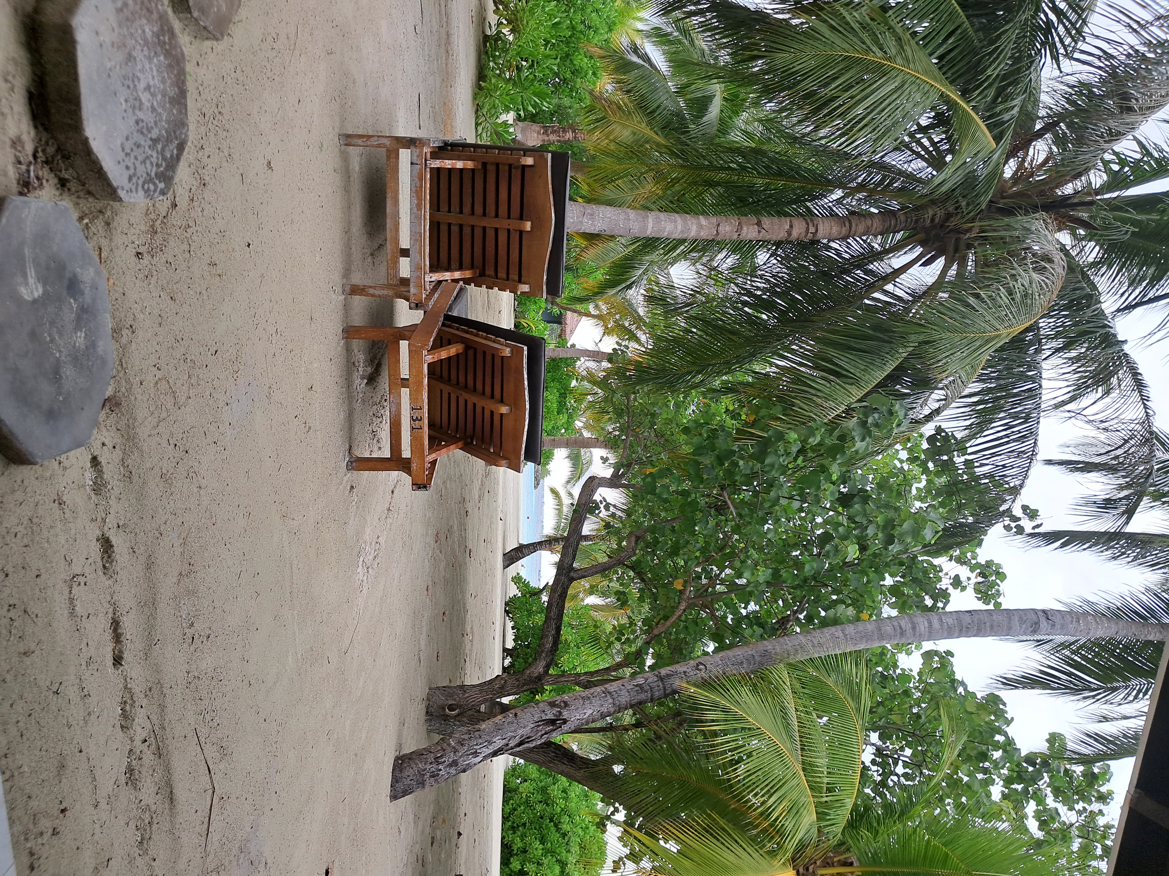 Sunset sailboat gliding past an overwater villa